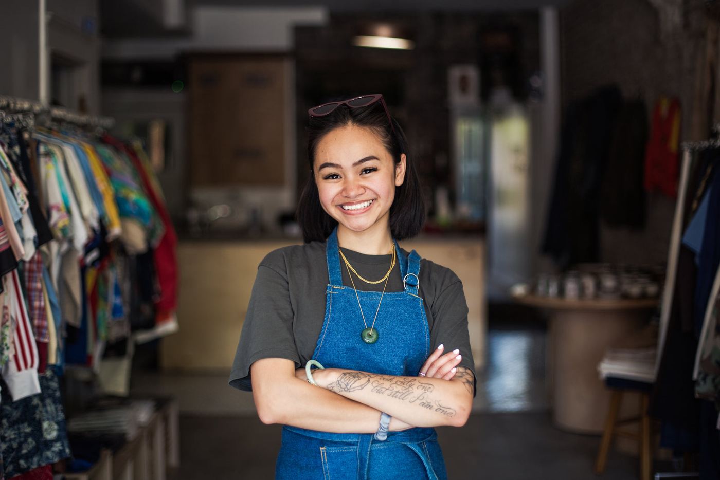 A smiling shop owner in an apron, standing in her store