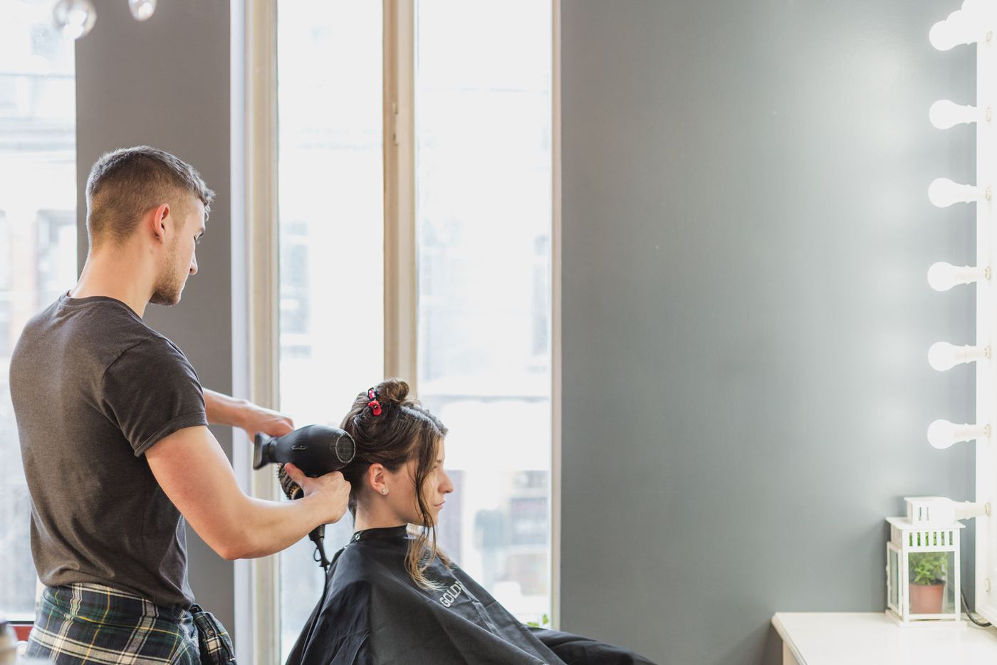 A stylist blow-drying a client's hair